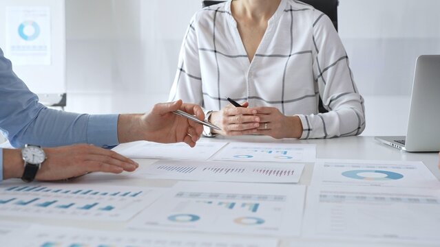 A business meeting with colleagues in a modern office where financial schedules, work planning, and reports are discussed in a team effort