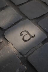 Letter a carved into stone pavement creates an artistic and unique street surface design