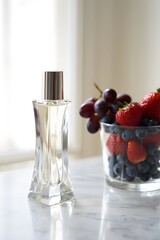 Perfume bottle with fresh fruit still life composition on a bright marble surface top