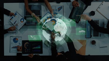 Aerial view of a business team engaged in a strategic meeting focused on sustainability and planning. Digital globe overlay emphasizes global impact and responsibility. Raster - Powered by Adobe