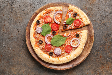 Board of tasty pizza with basil and tomatoes on dark background