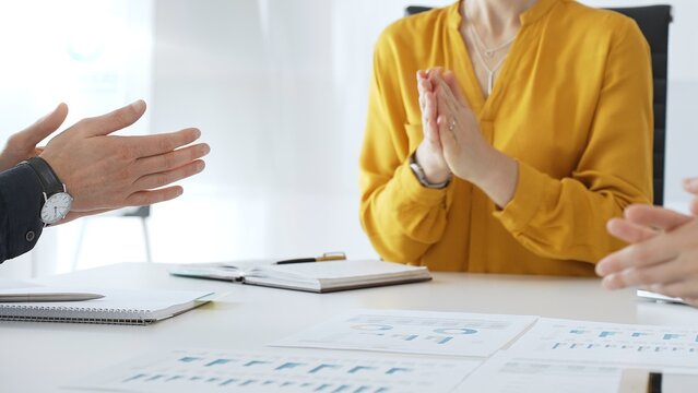Business colleagues clapping hands after successful presentation or good news during a corporate meeting, celebrating achievement and success in office