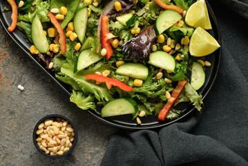 Plate with fresh vegetable salad on brown background
