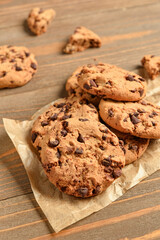 Tasty cookies with chocolate chips on wooden background