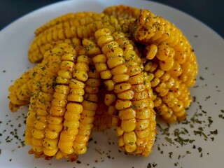 Air fried golden corn ribs with spicy herb seasoning on a white plate