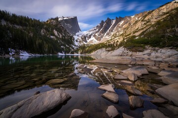 Emerald lake landscape with mountains and reflections in the water on a sunny day