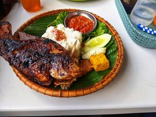 grilled tilapia, white rice and fresh pegetables and chili sauce served