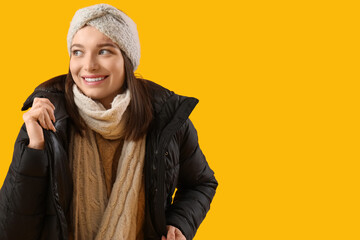 Young woman in winter clothes on yellow background © Pixel-Shot