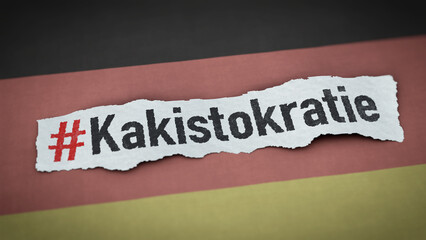 Papierschnipsel mit dem Wort Kakistokratie auf Deutschlandfahne