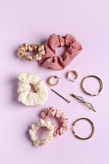 Earrings with hairpins and scrunchies on lilac background