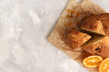 Panettone with slice of orange on parchment. Top view