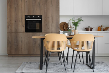 Interior of light kitchen with dining table and white counters