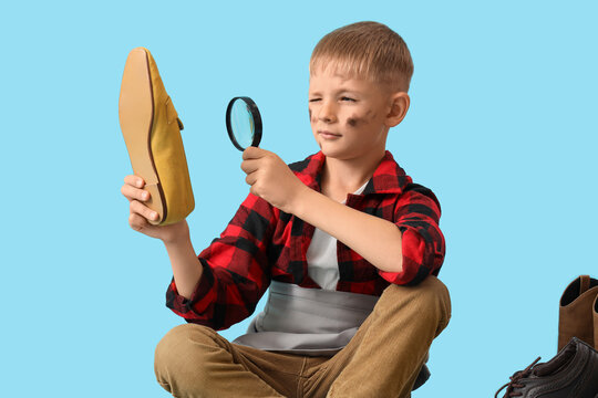 Cute little thoughtful cobbler with magnifier examining shoe on blue background - Powered by Adobe