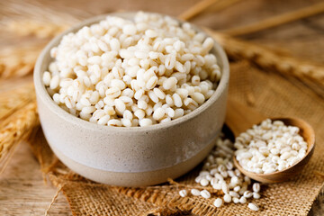 Closeup of cooked barley grains on wooden table.