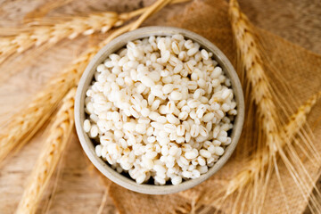 Closeup of cooked barley grains on wooden table.