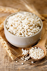Closeup of cooked barley grains on wooden table.