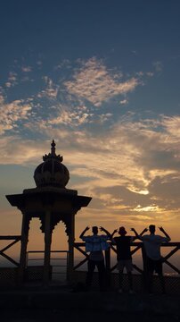 Young man enjoying the sunset and evening view at Samai Mata Mandir, Banswara, near Udaipur, Rajasthan, India, raising his hand in satisfaction while admiring the beautiful landscape.