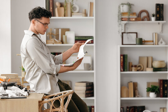Male screenwriter reading script in office