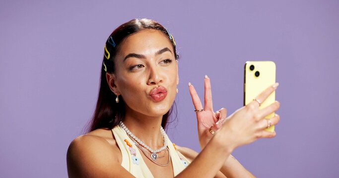 Beauty, peace sign and selfie with influencer woman in studio for product review on social media. App, haircare and pout of gen z content creator isolated on purple background for post or update