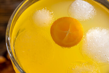 citrus-flavored orange juice and fresh kumquat fruits on a wooden table, delicious and fresh orange juice close up