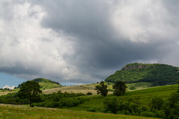 Beautiful mountain scenery with wavy wild grass fields in spring, in a wild area in Europe