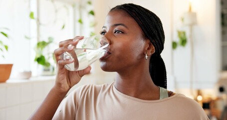 Home, hydration and woman drinking water in kitchen for natural nutrients, thirsty and detox. Body...