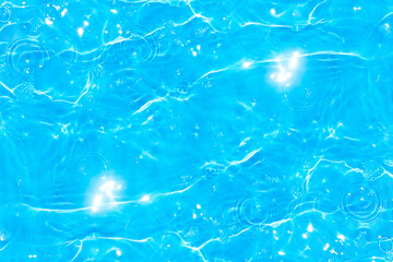 Blue water with ripples on the surface. Defocus blurred transparent blue colored clear calm water surface texture with splashes and bubbles. Water waves with shining pattern texture background.