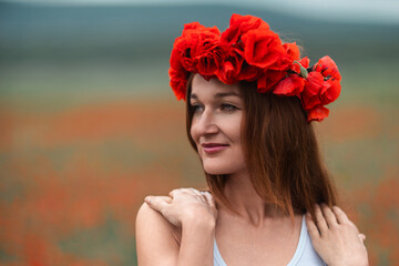 Naklejka premium Woman poppy wreath portrait beautiful woman wearing red flowers in blooming field copy space