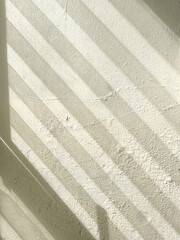 Sunlight and striped shadow on damped, musty old painted wall. Closeup textured exterior toilet wall in room at dhamma retreat center, Saraburi, Thailand. 25 OCT 2025. A.M.