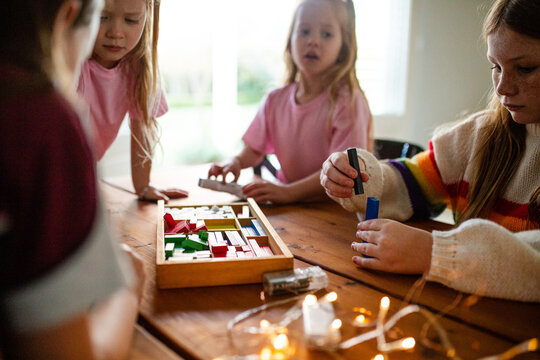 Young girls playing colourful rectangular blocks on the table