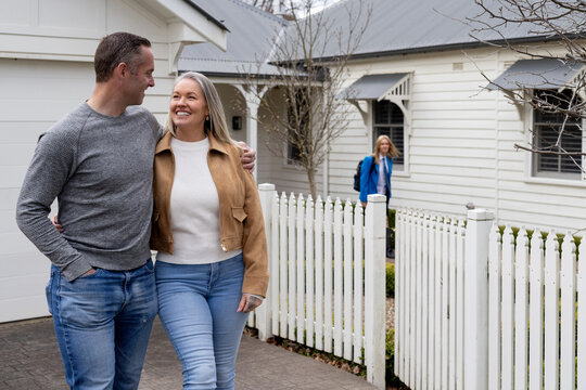 Couple walking outside picket fence