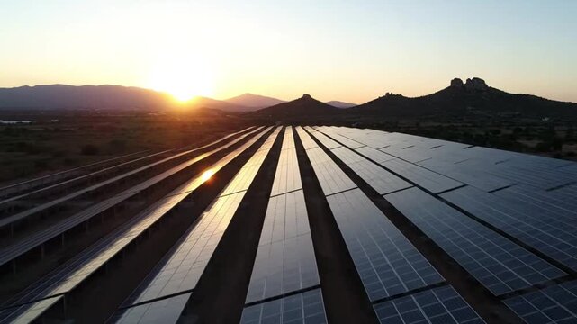 Solar panels on a rooftop with mountains and sunset in the background