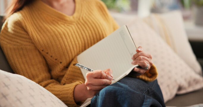 Woman, hands and writing on sofa with journal for planning goals, creative idea or process emotions. Daily reflection, notes or person in home with diary for self improvement, inspiration or insight.