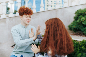 Redhead boy cheering up an upset girl while playing together on steps