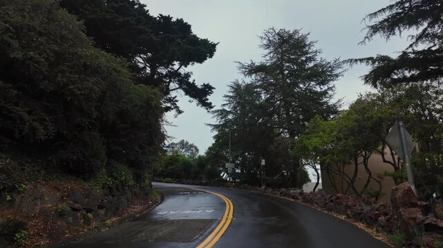 Curved road on Telegraph Hill in San Francisco leading to Coit Tower on a rainy day