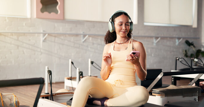 Gym, headphones and woman with smartphone, online and streaming music on break, app or entertainment. Health club, wellness and person with mobile for song selection, happy and subscription for audio