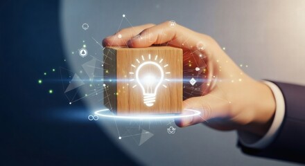 Innovation and creative idea development – hand grasping wooden cube with digital light bulb and futuristic tech network