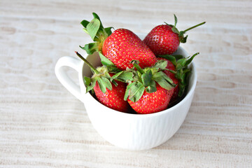 a close up of Fresh Red Strawberries in a White Cup