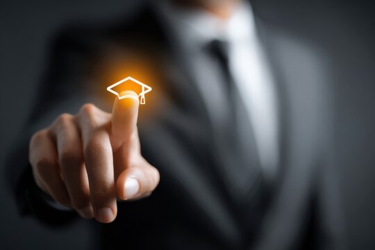 Businessman engaging in concept learning by interacting with a digital graduation cap symbol, showcasing innovative education methods for professional growth