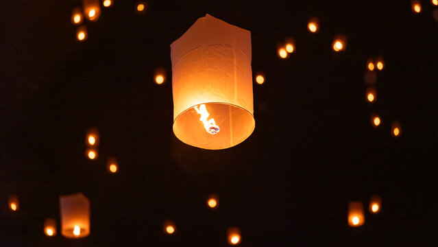 Sky lantern floating in the dark night sky, Tourist floating sky lanterns, Sky lanterns floating on night of Yi Peng, Loy Krathong Festival or Yi Peng Festival in Chiang Mai Thailand.