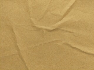 Crumpled brown kraft paper texture background with copy space for design. Old vintage paper surface with natural wrinkles and rough texture.