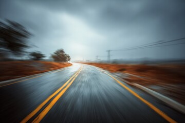 Naklejka premium Abstract blur of a winding motor road in rainy weather with dark clouds and a sense of motion captured in the background