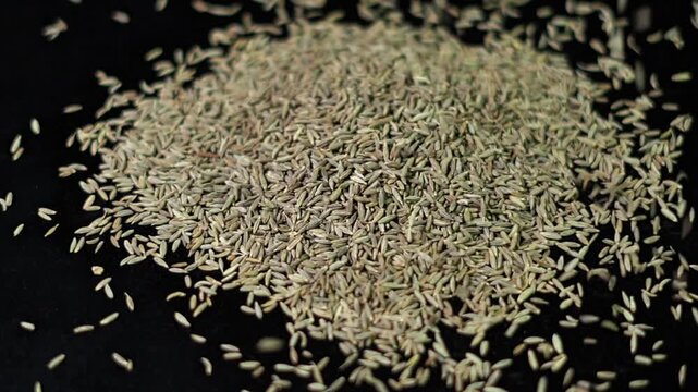 close up of Cumin seeds slow motion on black background.