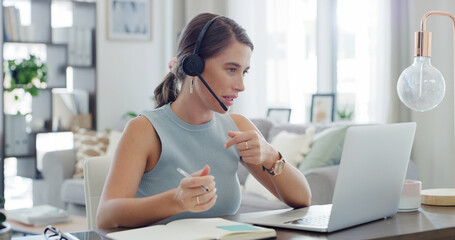 Headset, laptop and notebook with woman in living room of home for customer service or support. Communication, computer and writing with freelance employee in apartment for help or remote work