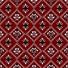 A rich, textured fabric pattern featuring ornate floral designs in white on a deep red background, creating a classic and elegant aesthetic.