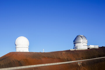 Fototapeta premium Twin white observatory domes on rust colored volcanic ridge