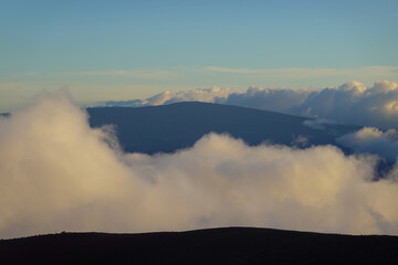 Soft evening light over distant ridges and glowing cloud ocean