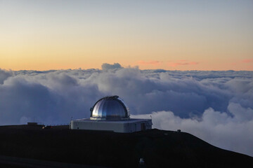 Solitary observatory dome watching soft dawn light above distant clouds