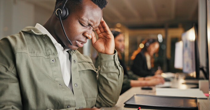 Call center, customer service and man in office with headache from burnout, telecom or working overtime. Late, tired male person and migraine at night with client complaint, bad review or mistake