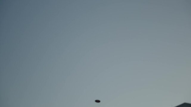 Flight of a throwing disc against the background of the sky. Shot in slow motion